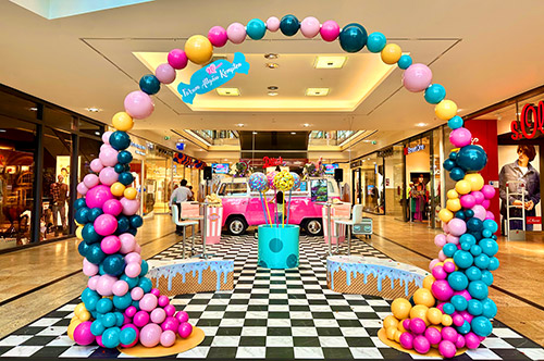 Centergeburtstag Dekoration mieten Candy Style mit Bubble Bogen und rosa VW Bulli, XL Popcorntüten und Waffel-Sitzpodeste